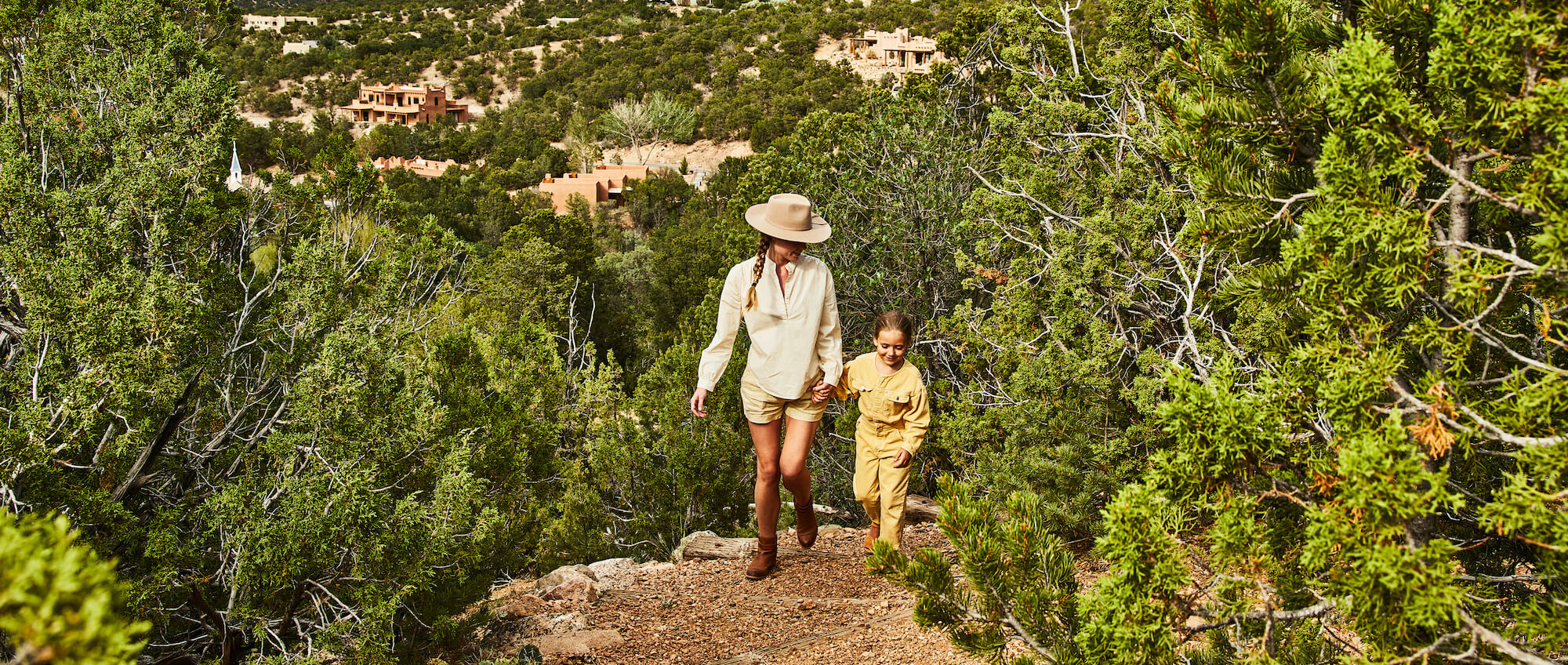 Mother and child hiking through the New Mexico desert.